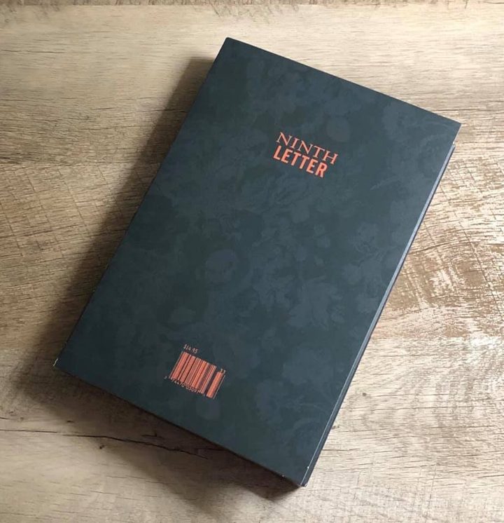 A copy of Ninth Letter with a dark floral cover and orange title, lying on a wood floor